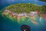 Stock photo of a small rocky island with a clear view through the water to the rocks below in Lake Superior during a flight from Thunder Bay, Ontario, Canada.