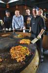 Stock photo of the Chef preparing meals while guests gather around to watch at the Mongolie Grill World Famous Stirfry Restaurant in Whistler Village, British Columbia, Canada. 