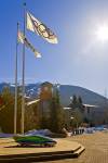 Stock photo of Olympic flags and the Vancouver 2010 bobsled displayed outside the Winter Olympic Office along the Village Stroll next to the BrewHouse in Whistler Village, with Blackcomb Mountain in the background, British Columbia, Canada. This photo was