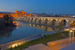 Puente Romano bridge spans Rio Guadalquivir to Mezquita at dusk in City of Cordoba Andalusia