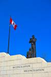 Stock photo of Reconciliation - the peacekeeping Monument and a Canadian flag in the city of Ottawa, Ontario, Canada.