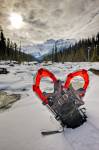 Stock photo of snowshoes stuck in the snow along the Mistaya River bank with Mount Sarbach in the background, Mistaya Canyon, Banff National Park, Alberta, Canada.