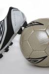 Stock photo of Soccer shoe leaning against a soccer ball.