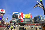 Stock photo of people, buildings, and sky on Yonge Street (a major arterial street) at Dundas Square, Downtown Toronto, Ontario, Canada.