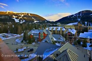 Stock photo of Blackcomb and Whistler Mountains as seen from the Pan Pacific Hotel in Whistler Village, British Columbia, Canada. Although the village and most of the mountains are in shadow, it is a bright sunny day with clear blue sky in the background.