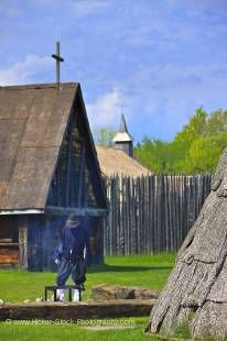 Stock photo of historically dressed character tending a fire in the Native Area of the Sainte-Marie among the Hurons complex in the town of Midland, Ontario, Canada.
