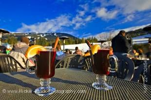Stock photo of glasses of hot gluehwein (mulled wine) served at the Longhorn Saloon and Grill an apres-ski bar at the base of Whistler Mountain, Whistler Village, British Columbia, Canada. A bright blue sky with few clouds provides a lovely background to 