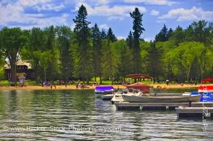 Stock photo of people enjoying the afternoon on the sandy shore of Clear Lake in Wasagaming, Riding Mountain National Park, Manitoba, Canada.