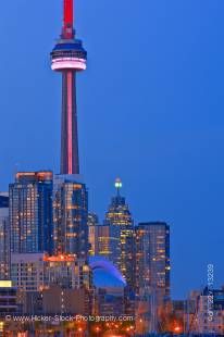 Stock photo of the CN Tower and many of the tallest buildings all lit up as the sky fades from deep blue to night as seen from Ontario Place, Toronto, Ontario, Canada at dusk.