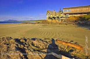 Stock photo of the Wickaninnish Interpretive Centre along Wickaninnish Beach against a bright blue sky over Wickaninnish Bay in Pacific Rim National Park, Long Beach Unit, Clayoquot Sound UNESCO Biosphere Reserve, West Coast, Pacific Ocean, Vancouver Isla