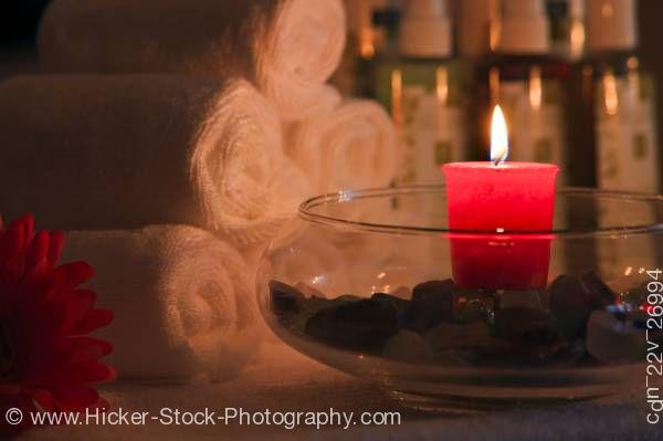 Stock photo of Red candle glowing with towels in background.