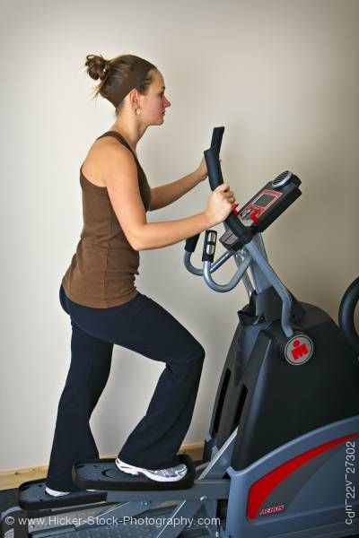 Stock photo of Woman working out elliptical trainer