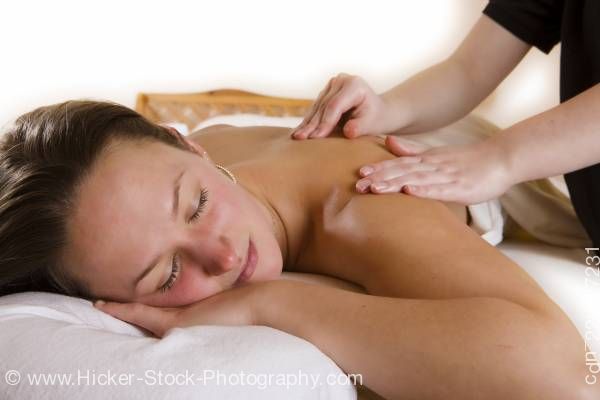 Stock photo of Young Woman Receiving Relaxing Back Massage Treatment From A Therapist 